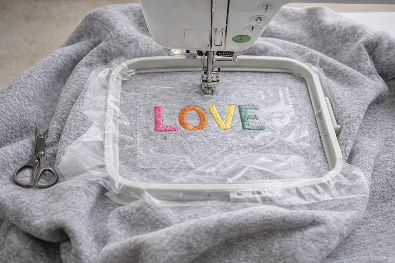 Broderie machine sur sweat en molleton avec stabilisateur cut-away et film hydrosoluble, motif brodé sans déformation du tissu extensible