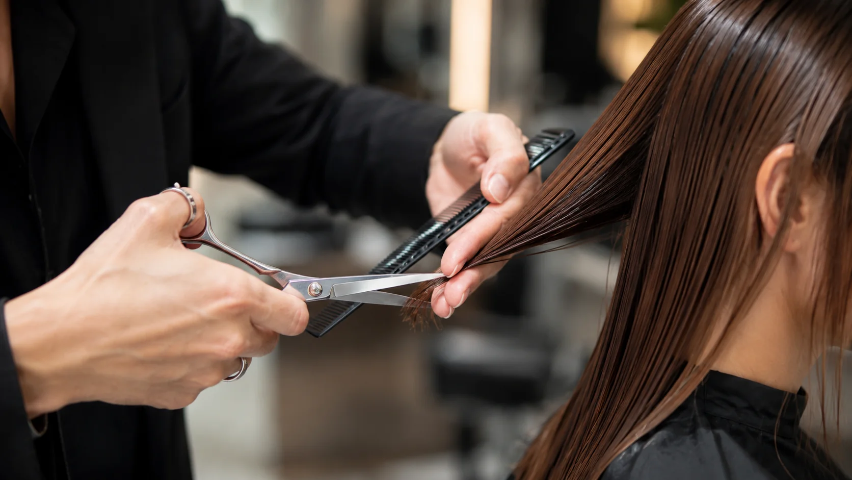 Gros plan sur une coupe de cheveux au ciseau avec peigne dans un salon de coiffure