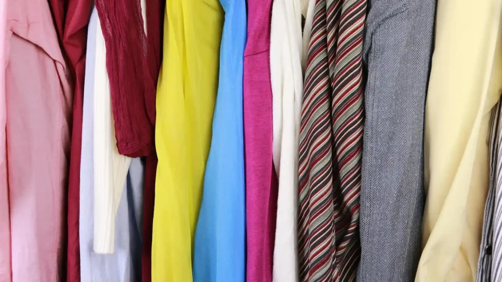 Vêtements colorés suspendus dans une penderie avec chemises, vestes et cravates