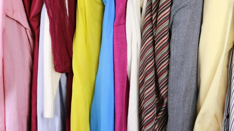 Vêtements colorés suspendus dans une penderie avec chemises, vestes et cravates